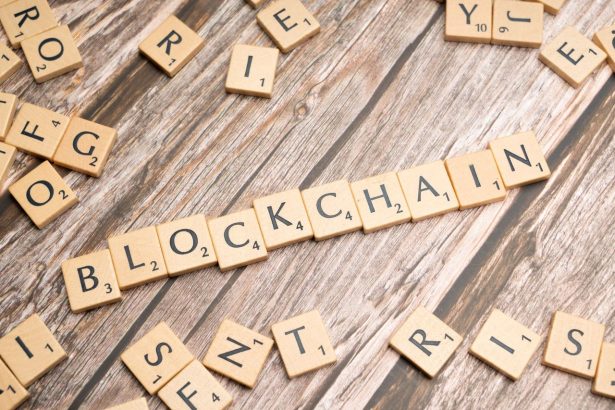 Peças de madeira formam a palavra “blockchain” sobre uma superfície de madeira.